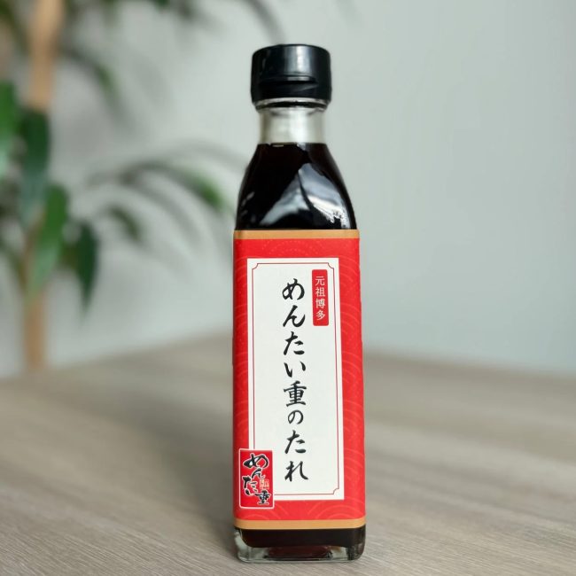 「元祖博多 めんたい重のたれ」と書かれた赤いラベルのボトルが写っています。めんたい重にかける専用のたれで、博多名物の明太子を使った調味料と推測されます。
